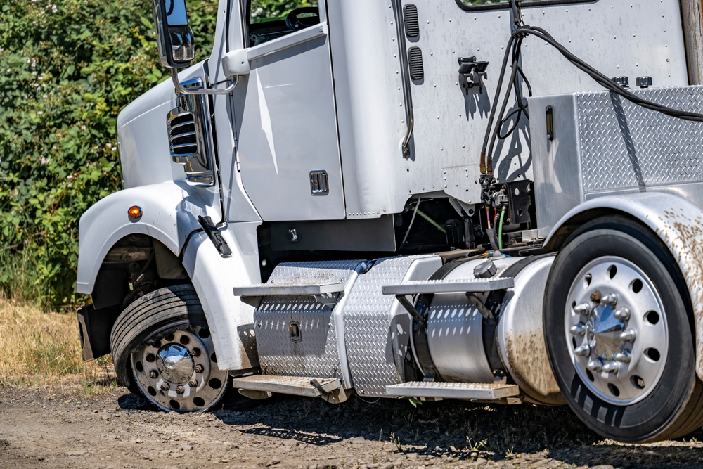 A semi truck with a flat tire parked on the roadside, highlighting the importance of knowing your rights after a truck accident.